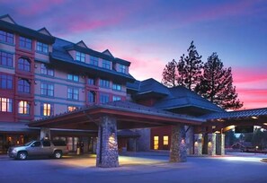Traditional hotel with a covered entrance and stone pillars.
