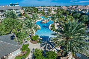 A resort with a central swimming pool, multiple-story buildings, and palm trees. - Beach Trolley, Beautiful Neighborhood Pool, Close to Shops (Destin)