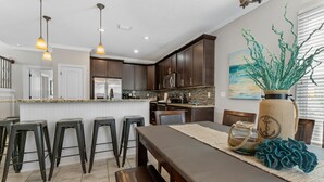 Una cocina moderna con armarios de madera oscura, encimera de granito e isla central con taburetes de bar.