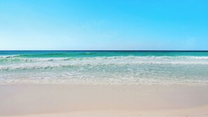 Una playa con aguas azul turquesa y una orilla arenosa.