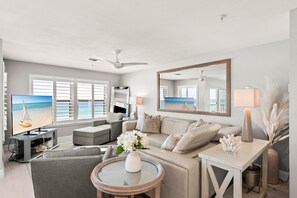 A modern living room with a television, sofa, and coffee table. - Gulf Front, Gated Community (Destin)