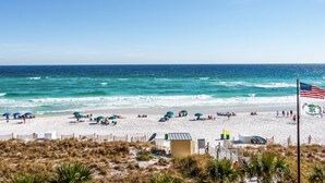 A beach with umbrellas, a lifeguard tower, and an American flag. - Gulf Front * Endless Beach Views * Private Balcony * Pool, Hot Tub, Tennis (Destin)