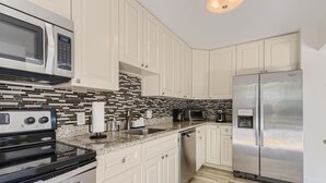 A modern kitchen with white cabinetry, a stainless steel refrigerator, a microwave, a stove, and a dishwasher. - 🌴🐠🍹Tropical Beachside Pool House!  Live your best life! (Pompano Beach)