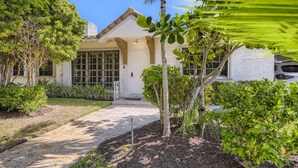 A house with a front porch, a garage, and a driveway. - 🌴🐠🍹Tropical Beachside Pool House!  Live your best life! (Pompano Beach)