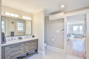 Un baño moderno con un espejo grande, lavamanos dobles y una ducha a ras de suelo.