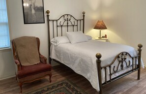 Ein Schlafzimmer mit Bett, Stuhl, Lampe und Teppich.