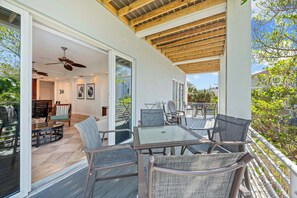 An outdoor patio with a table and chairs, a ceiling fan, and a view of the surrounding area. - A Somewhere is Here by Beachside Management  (Siesta Key)