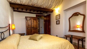 Un dormitorio con cama, armario de madera y espejo.