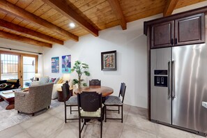 Enjoy meals in this stylish dining area with a wooden table and comfortable seating for four.