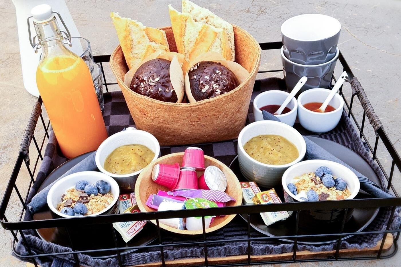 A breakfast tray with bread, jam, soup, and cereal.