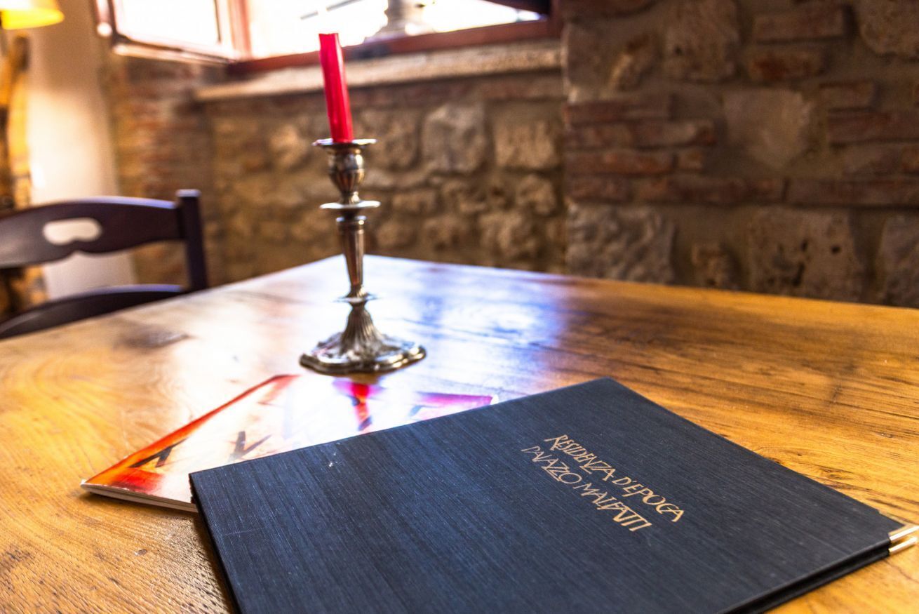 Une table en bois sur laquelle se trouve un dossier noir portant l’inscription « KIRKWOOD DEPOT » et un porte-bougie rouge.