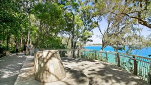 A wooden deck with a railing overlooking a body of water.