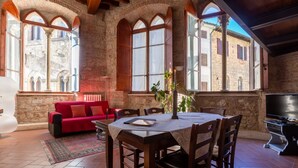 A dining area with a round table, chairs, and a red sofa.