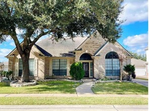 Stunning facade with a central entrance, flanked by two windows, set amidst a beautifully landscaped lawn.
