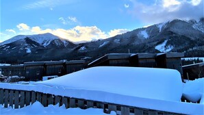 A snow-covered mountain landscape with a wooden building in the foreground.