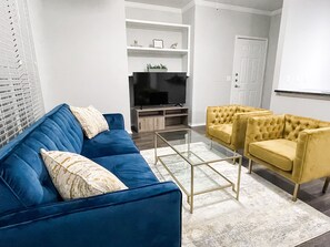 Relax in this stylish living room with a sofa, armchairs, and flat-screen TV.