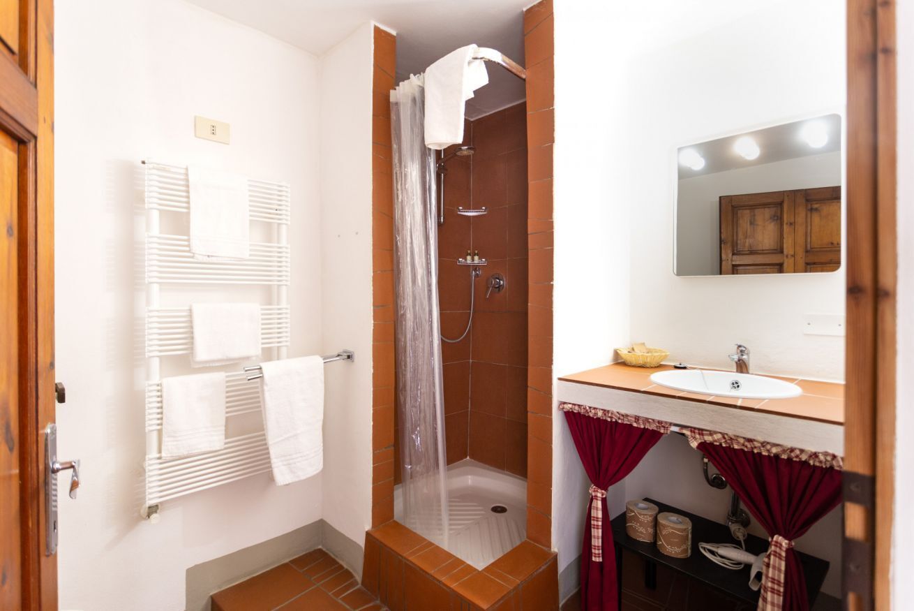 Ein Badezimmer mit Dusche, Waschbecken und Spiegel.