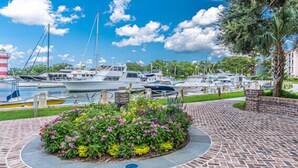 A marina with boats docked, a brick pathway, and a flower bed. - RESTFUL RETREAT! (Hilton Head Island)