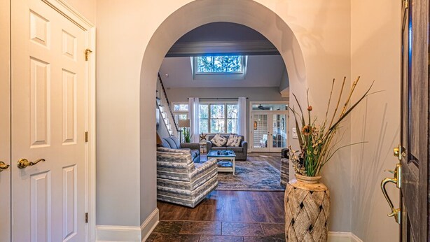 A hallway with a vaulted ceiling, a staircase, and a living area with a sofa and coffee table. - RESTFUL RETREAT! (Hilton Head Island)