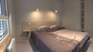 Ein Schlafzimmer mit Bett, Nachttischen und einem Kleiderschrank.