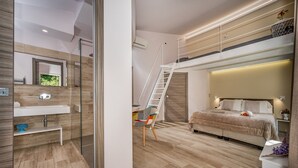 Een moderne slaapkamer met een hoogslaper, een douchecabine met glazen wanden, een witte wastafel en een houten vloer.