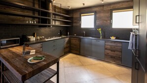 Eine moderne Küche mit dunklen Holzschränken, einem Edelstahlkühlschrank und einem eingebauten Backofen.