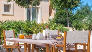 A breakfast setup with a table, chairs, and various breakfast items. - Villa Passo degli Aironi 12, Emma Villas (Noto)