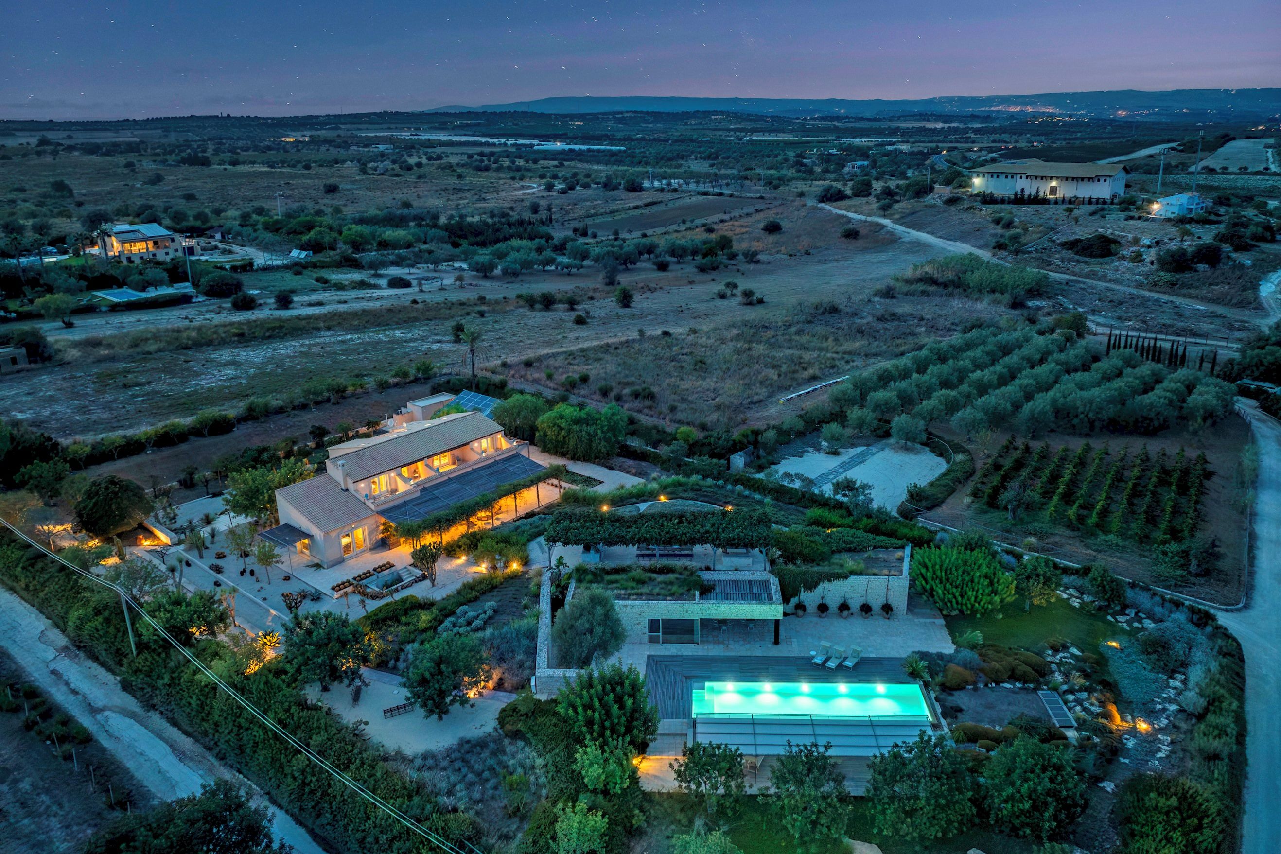 A large estate with multiple buildings, a swimming pool, and extensive landscaping.