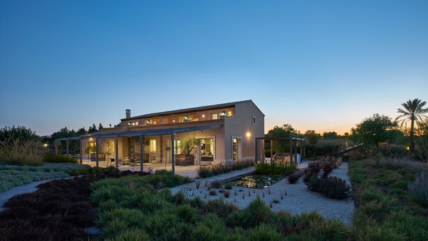 A modern house with a covered patio, a small pond, and landscaped garden. - Villa Majoli 9, Emma Villas (Noto)
