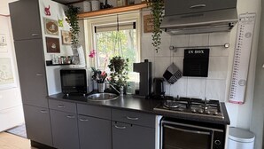 A modern kitchen with grey cabinets, a built-in oven, and a stainless steel sink.