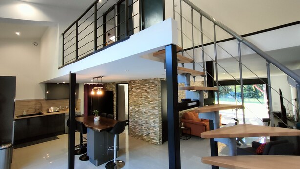 A modern kitchen with a dining area, a staircase, and a living room with a sofa and a coffee table. - House garden swimming pool play in the country (Camélas)