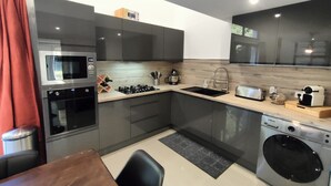 A compact kitchen with a microwave, oven, sink, and washing machine. - House garden swimming pool play in the country (Camélas)