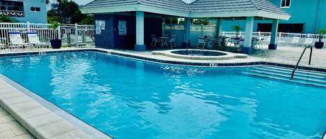Ein Swimmingpool mit einer Tiefenmarkierung von 1,4 Metern, umgeben von Liegestühlen und Sonnenschirmen.
