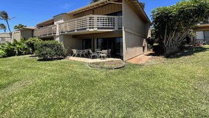 A two-story building with a balcony and a patio area with outdoor furniture. - "Front Row"  Ocean & Island Views 2 Bedroom (Maunaloa)