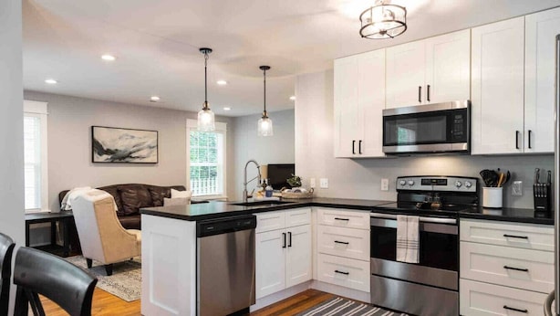 A modern kitchen with white cabinets, stainless steel appliances, and a central island. - Bearden Exec · Bearden Executive Rental >8min to UT & Downtown (Knoxville)