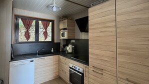 Eine moderne Küche mit Holzausstattung, einer Spülmaschine, einer Mikrowelle und einem Herd.