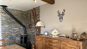 Ein Holzespeisetisch mit rustikalem Design, eine Steinwand mit Kamin und eine Holzkommode mit Dekorationen.