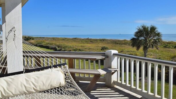 A balcony with a hammock, a wooden bench, and a view of the beach and ocean. - Beautiful Beachfront -- Biscayne Fantasea (Bolivar Peninsula)