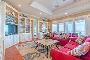 Relax in this inviting living room with a large sofa, coffee table, and shelving.