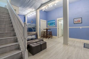 Stairs lead to an upper level in this stylish space, featuring artwork and a dining area.