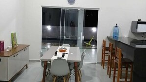 Una cocina moderna con comedor, que cuenta con un ventanal grande, un reloj y un dispensador de agua.