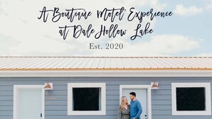 Un motel boutique con una fachada sencilla, un letrero que dice 'The Cottage Inn', y una pareja parada al frente.