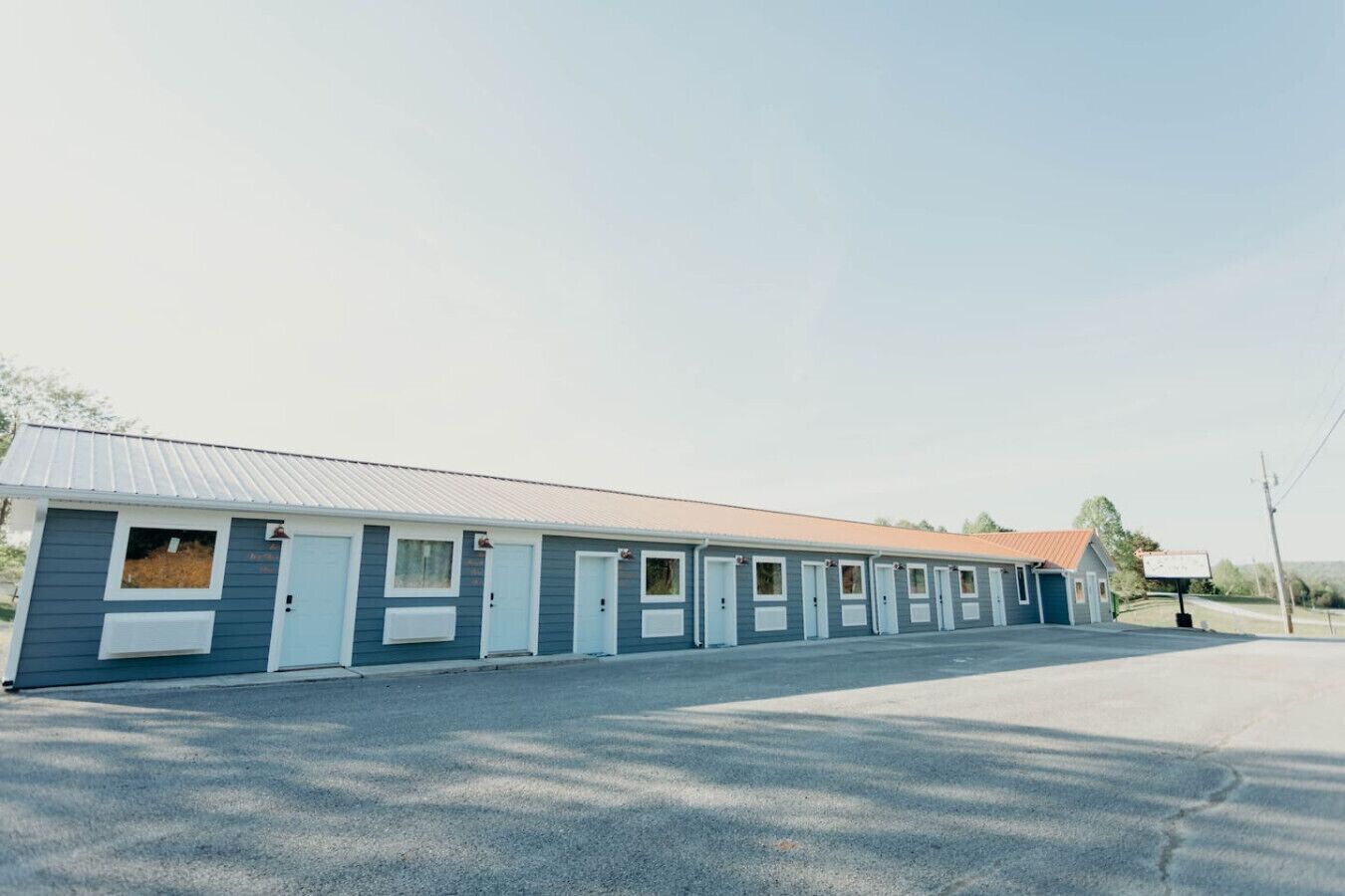 Una hilera de habitaciones de motel de un piso, cada una con su propia entrada y ventanas pequeñas.