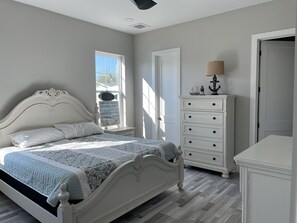 Une chambre à coucher avec un lit, une commode et une fenêtre.