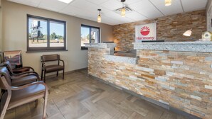 A reception area with a stone wall, a 'Harmony' sign, and a seating area with chairs.