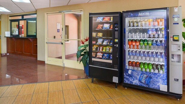 Un hall d’hôtel équipé d’un distributeur automatique rempli de collations et de bouteilles d’eau.