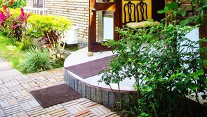 Um edifício de dois andares com fachada de tijolos, janelas amplas e uma porta amarela.