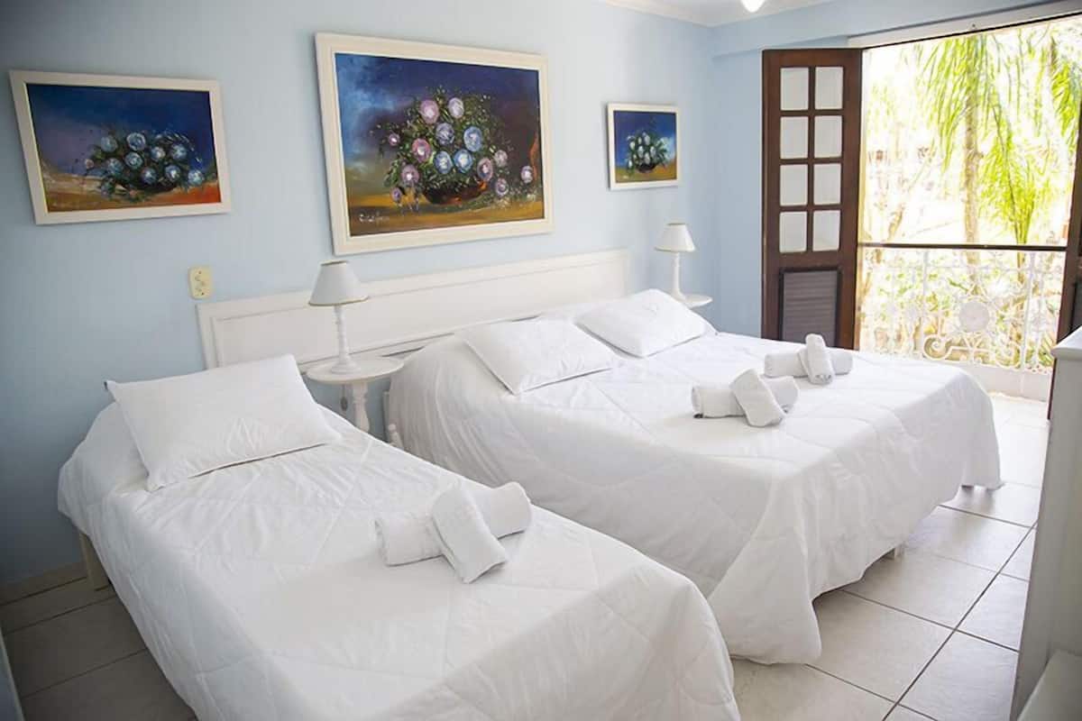 Ein Hotelzimmer mit zwei Betten, weißer Bettwäsche und Bildern an den Wänden.