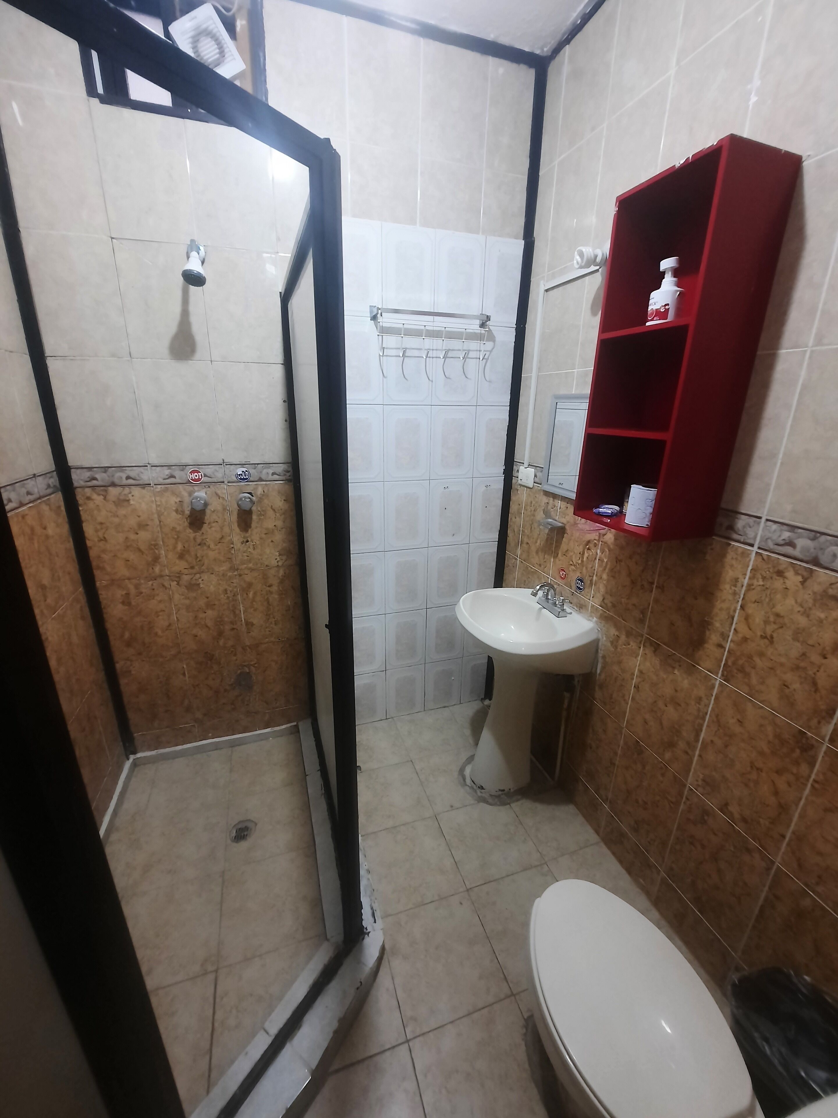 A bathroom with a shower, sink, and toilet.