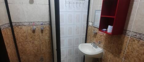 A bathroom with a shower, sink, and toilet.